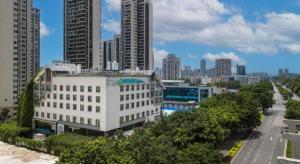 a large white building in a city with tall buildings at City Comfort Inn Liuzhou Chengzhong Wanda Plaza in Liuzhou