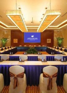 une salle de conférence avec des tables et des chaises bleues et un écran dans l'établissement New Century Shaoxing Grand Hotel, à Shaoxing 130 autres photos