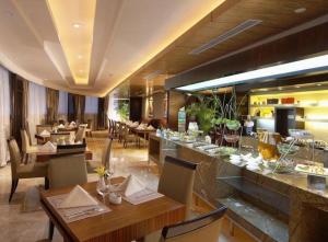 un restaurant avec des tables et des chaises et un bar dans l'établissement New Century Shaoxing Grand Hotel, à Shaoxing