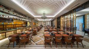 ein Esszimmer mit Reihen von Tischen und Stühlen in der Unterkunft Country Garden Phoenix Hotel Jurong in Huangmeiqiao