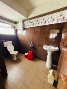 a bathroom with a toilet and a sink at Hotel caveri comfort in Madikeri