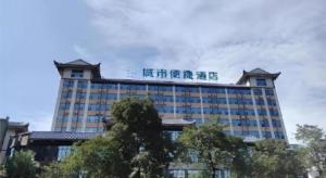 a building with a sign on top of it at City Comfort Inn Meishan Sansu Temple in Meishan
