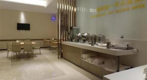 a restaurant with a counter and a table and chairs at City Comfort Inn Meishan Sansu Temple in Meishan