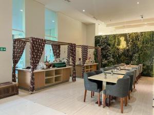 ein Esszimmer mit einem langen Tisch und Stühlen in der Unterkunft Horison Nindya Semarang in Alastuwo