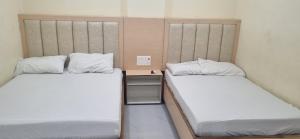 two beds sitting next to each other in a room at Sri Srinivasa Lodge in Mārkāpur