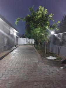 a cobblestone street with a tree and a building at Rest Haven Apartments Meanwood in Lusaka