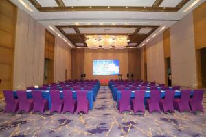 a conference room with purple chairs and a projection screen at Sanya Shuangda Adelaide In Resort Hotel in Sanya +204 photos