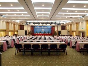 a large banquet hall with tables and chairs and a screen at Tong Da International Hotel in Zhangjiajie