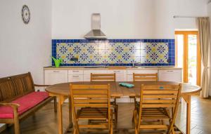 a kitchen with a wooden dining table and chairs at Monasterace 288 in Marina di Monasterace