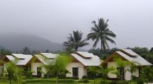 a white house with palm trees in front of it at Pangsarapee Resort in Ban Bo Nam Khao +82 photos