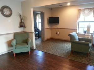 a living room with two chairs and a tv at Americas Best Value Inn & Suites - Little Rock - Maumelle in Maumelle