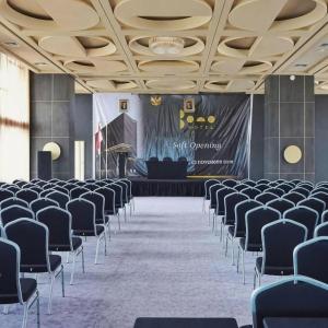 ein großes Zimmer mit Stühlen und einer Bühne mit einem Bildschirm in der Unterkunft The Bono Hotel Pekanbaru in Pekanbaru + 183 Fotos