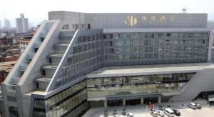 un grand bâtiment avec une enseigne sur le côté dans l'établissement Kunming Xiyi Hotel, à Kunming