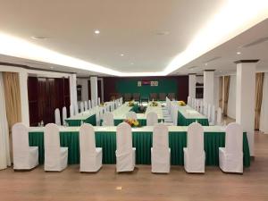 a conference room with a long table and white chairs at The Palm Hotel in Sihanoukville
