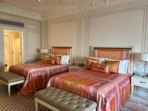 Un dormitorio con dos camas y un banco en él. en 澳门公关特价酒店, en Macau