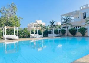 ein großes Schwimmbad vor einem Gebäude in der Unterkunft 3 Bedroom Deluxe Villa-Mfalme in Diani in Diani Beach