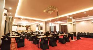 Un salón de banquetes con mesas y sillas en una habitación. en Grand Darmo Suite by AMITHYA, en Surabaya