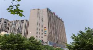 ein hohes Gebäude vor einigen Gebäuden in der Unterkunft City Comfort Inn Yongzhou Jinshuiwan in Guzhuting