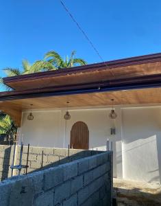 ein Gebäude mit einer Holztür und einer Ziegelwand in der Unterkunft Malinka House in Alegria