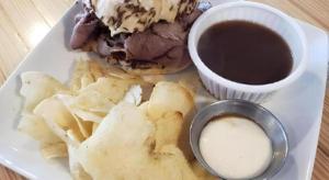 ein Teller mit einem Sandwich und Pommes und einer Tasse Soße in der Unterkunft Keuka Lake Motel in Keuka