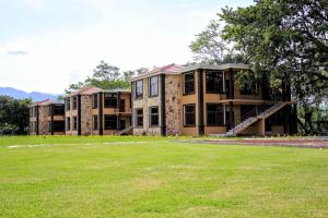 a large building with a grass field in front of it at Grand Caporal Hotel in Chiquimula