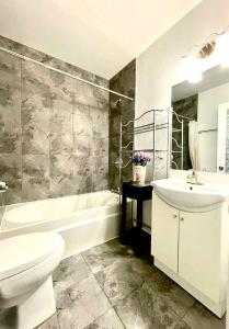 a bathroom with a tub and a toilet and a sink at Quiet King Bedroom near DT Toronto in Toronto