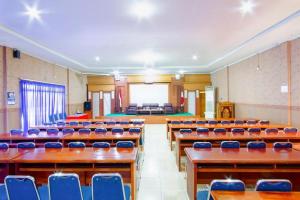 an empty lecture hall with blue chairs and desks at Hakmaz Taba Syariah Hotel in Tabahpingin +51 photos