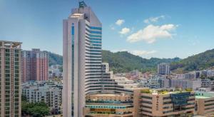 un grand bâtiment blanc dans une grande ville dans l'établissement Noble Jasper Hotel Huizhou, à Huizhou
