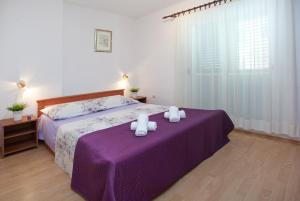 a bedroom with a purple bed with two towels on it at Bačvice beach apartment in Split