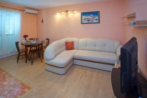 a living room with a white couch and a table at Bačvice beach apartment in Split
