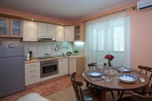 a kitchen with a wooden table and a dining room at Bačvice beach apartment in Split
