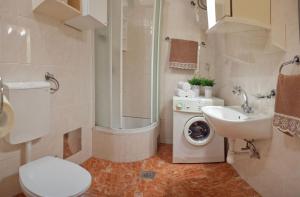 a bathroom with a toilet a sink and a washing machine at Bačvice beach apartment in Split +5 photos