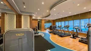 um ginásio com uma fila de passadeiras e elípticos em Burj Khalifa view - 2 BR apartment in Downtown em Sabkhah