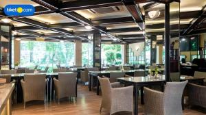 a restaurant with tables and chairs and a large window at Regent's Park Hotel at Kayutangan Malang in Malang