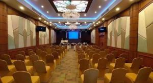 einen leeren Saal mit Stühlen und einem Kronleuchter in der Unterkunft Phitsanulok Orchid Hotel in Ban Phayom