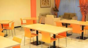 une pièce avec des tables, des chaises et un canapé dans l'établissement Hotel Kings Kudus, à Kudus