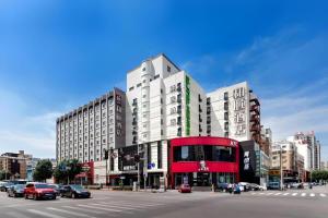 einem roten Doppeldeckerbus auf einer Stadtstraße in der Unterkunft Yitel Collection Shenyang Imperial Palace Zhongjie Metro Station in Shenyang