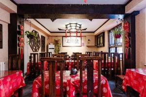 a dining room with tables and chairs and a chandelier at Beijing Double Happiness Courtyard Hotel in Beijing