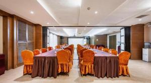 une grande salle de conférence avec une longue table et des chaises dans l'établissement JinJiang Inn Baoji Administra Tion Center, à Baoji