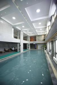 ein Swimmingpool mit blauem Wasser in einem Gebäude in der Unterkunft The Corporate Hotel and Convention Centre in Ulaanbaatar