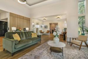 a living room with a green couch and a table at University Park Inn & Suites, an Ascend Collection Hotel in Davis