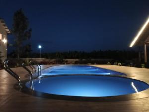 a large blue swimming pool at night at The Fox Resort, Bandipur in Bandipūr +12 photos