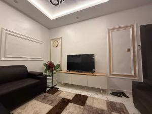 Una sala de estar con un sofá y un televisor. en Larj Residence, en Lagos