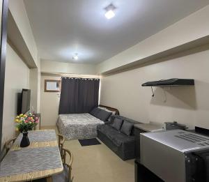 a living room with a couch and a bed at CDO City Center Avida Condo Fast Wifi in Cagayan de Oro