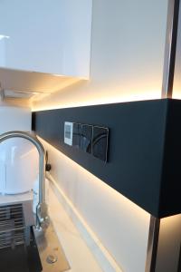 プレスタティンにあるGalactic getaways PLUTOの白黒の壁と洗面台のあるバスルーム +8枚の写真