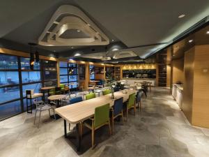 a restaurant with tables and chairs and a kitchen at Ibis Styles Shanghai Qingpu Sports Center Hotel in Qingpu