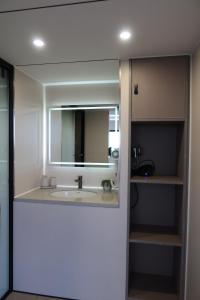 プレスタティンにあるGalactic getaways PLUTOの洗面台と鏡のあるバスルーム