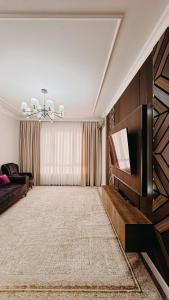 ein Wohnzimmer mit Sofa und Fernseher in der Unterkunft Жк Керуен Сарай in Türkistan