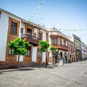 eine Straße in einer Stadt mit Gebäuden und Flaggen in der Unterkunft La Herbolera Vv in Teror + 25 Fotos