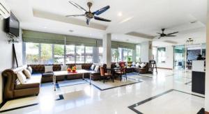 - un salon avec des canapés et un ventilateur de plafond dans l'établissement Treeyapat Place, à Ban Chuk Kum